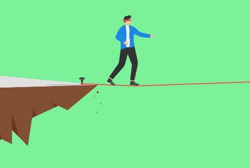 Blindfolded man walking on a high wire.