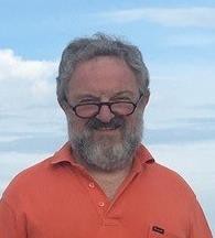 Bearded man smiling wearing orange polo