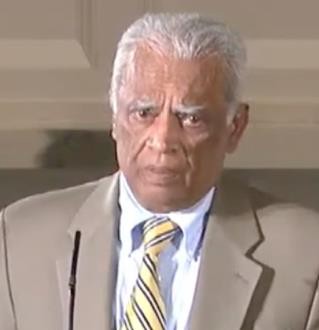 Older man in suit at podium