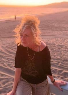 Woman seated on beach at sunset