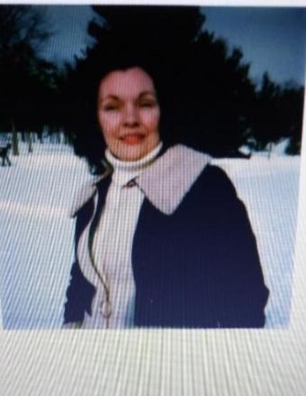 Woman standing outside in snowy landscape.