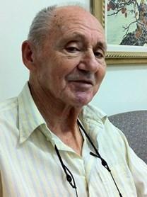 Elderly man smiling, seated indoors
