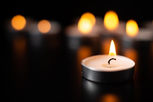 Burning tealight candles on black background.