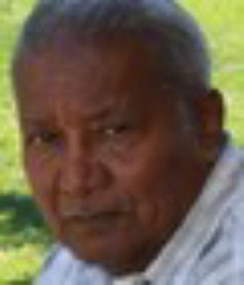 Elderly man outdoors with green background.