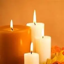 Lit candles with warm autumnal background.