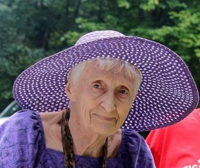 Older woman in purple sunhat outdoors