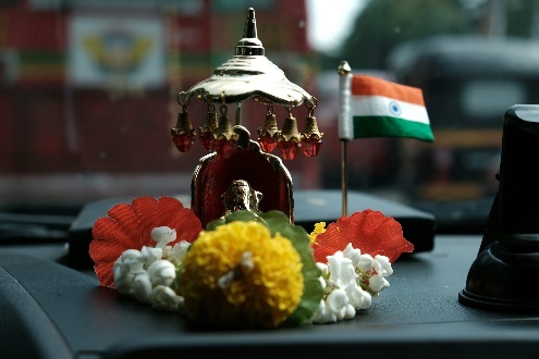 Car dashboard with flowers and Indian flag.