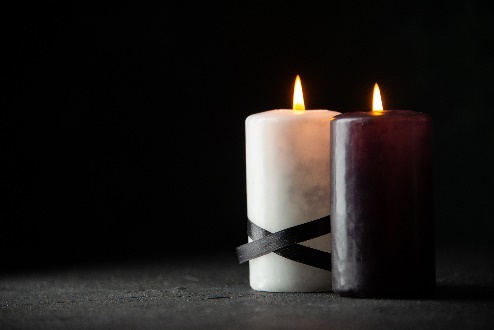 Lit white and black candles with ribbon.