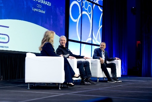 Panel discussion on stage with three speakers.