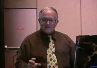 Man giving presentation beside laptop