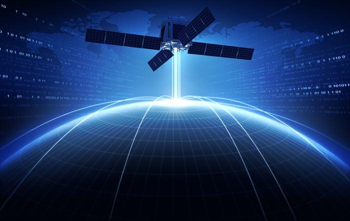 Satellite over illuminated Earth with binary code