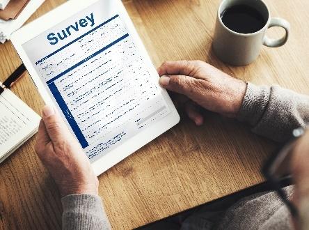 Tablet displaying survey next to coffee cup