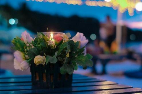 Flower centerpiece on outdoor table with bokeh lights