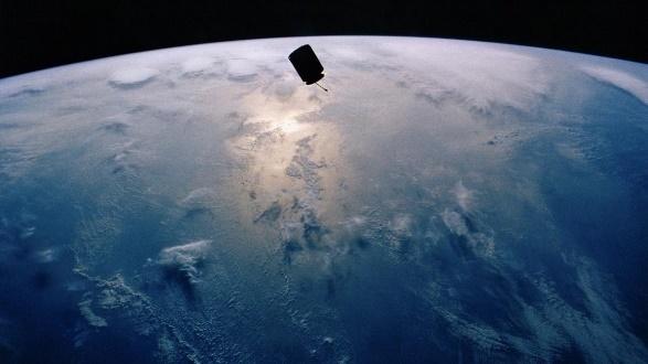 satellite orbiting Earth over ocean sunrise