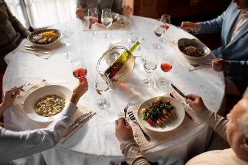 Group dining at round table with wine