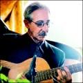 Man with sunglasses playing acoustic guitar