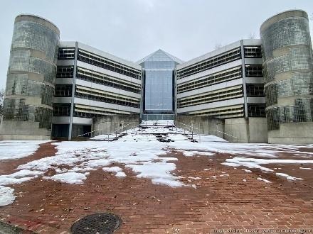 Modern concrete building with glass atrium and snow