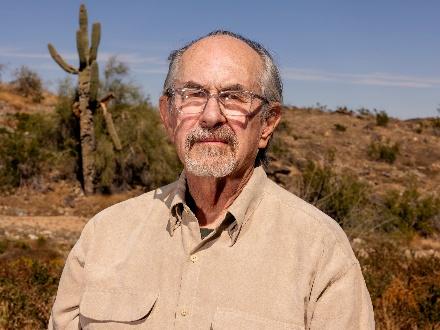 Elderly man standing in desert landscape