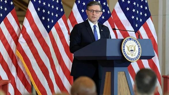 Person giving speech at podium with US flags