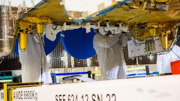 Image credit <a href="https://www.luxtimes.lu/" target="_blank" rel="noopener noreferrer">Luxembourg Times</a>: Technicians at satellite manufacturer Airbus work on an SES satellite launched in 2017 to deliver television signals to Latin America  © Photo credit: Airbus Defence and Space
